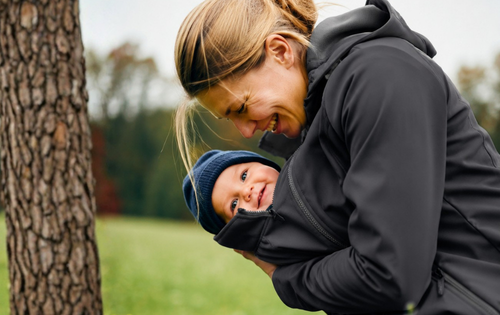 mama-lachend-mit-baby-in-schwarzer-jacke