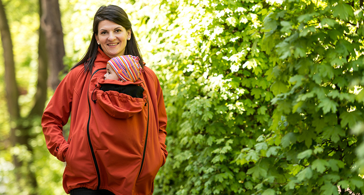 Mother walks with child under the jacket