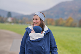 Mutter trägt kind unter der Jacke
