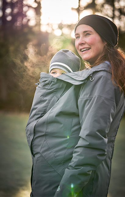 Mama trägt Kind unter der Jacke