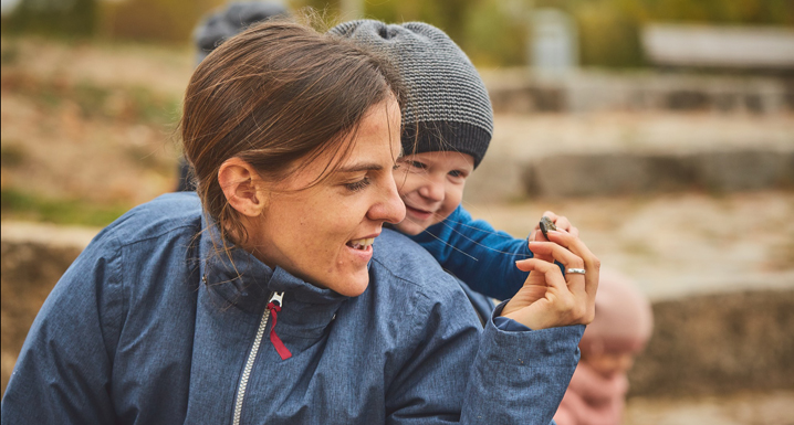 Mother and child with winter carrying jacket in autumn in nature