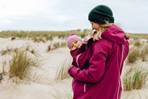 Mother with child in a carrier at the beach